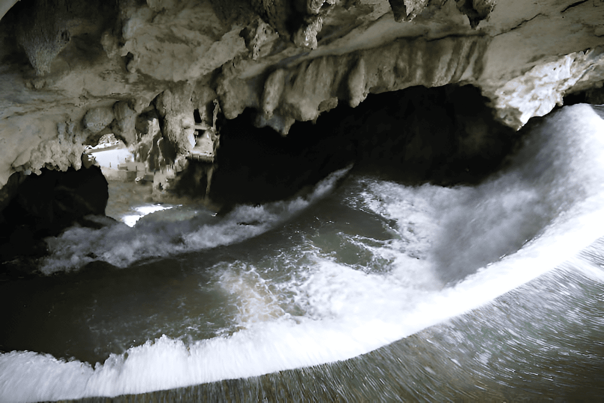waterfall and underground river inside Dragon’s Palace Longgong Caves