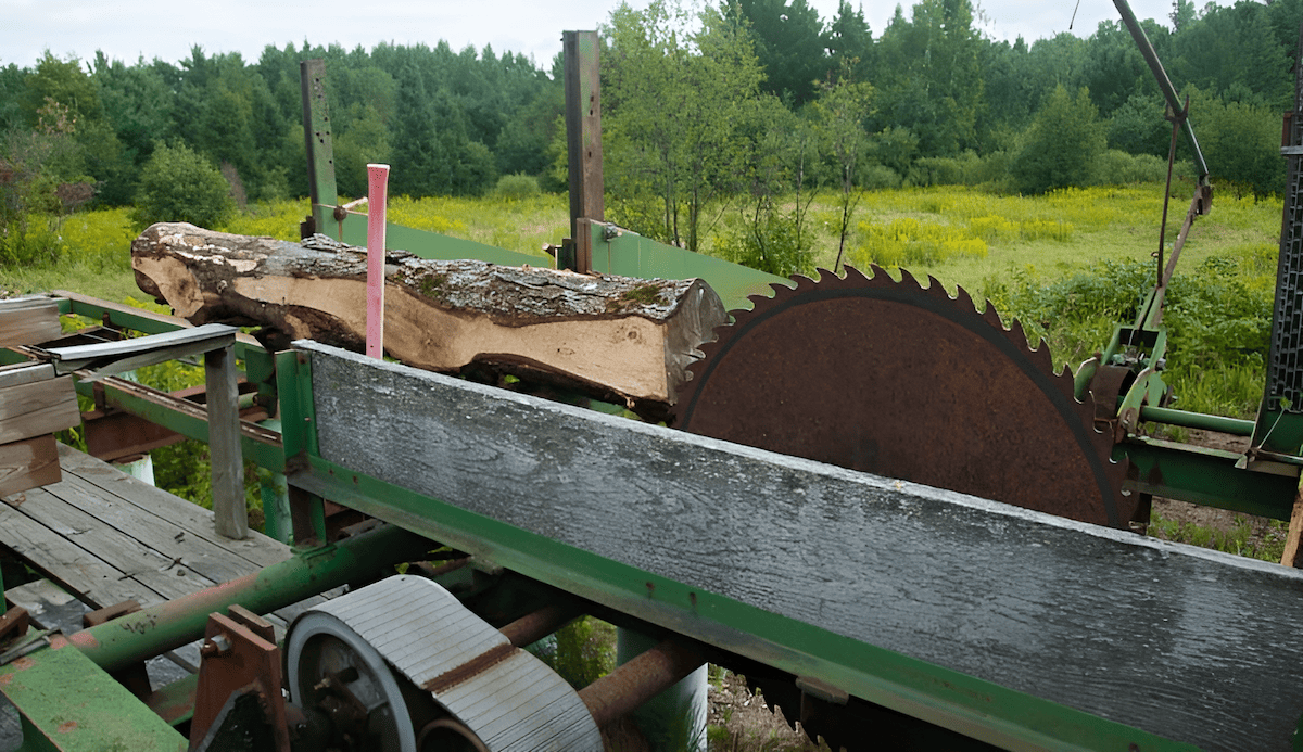 PTO-driven portable sawmill powered by a farm tractor in the woodlot