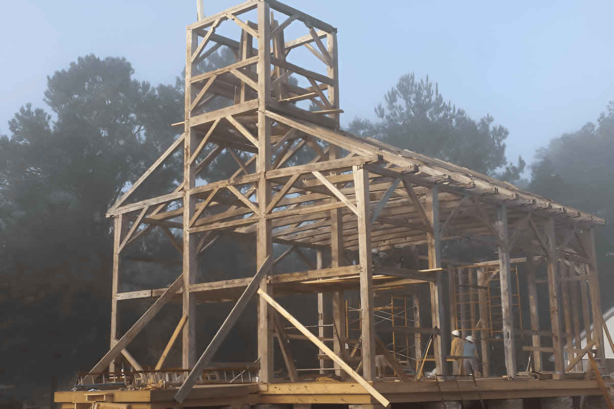 timber frame church under construction with exposed beams and trusses